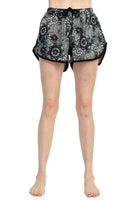 Women’s boho drawstring shorts with a black lace-style mandala pattern on a light gray background, finished with black trim and curved side hems for a relaxed fit.